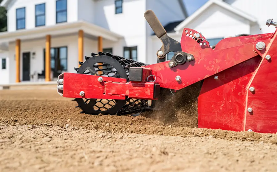 Cultivator attachment used to condition surface soil during site preparation before landscaping